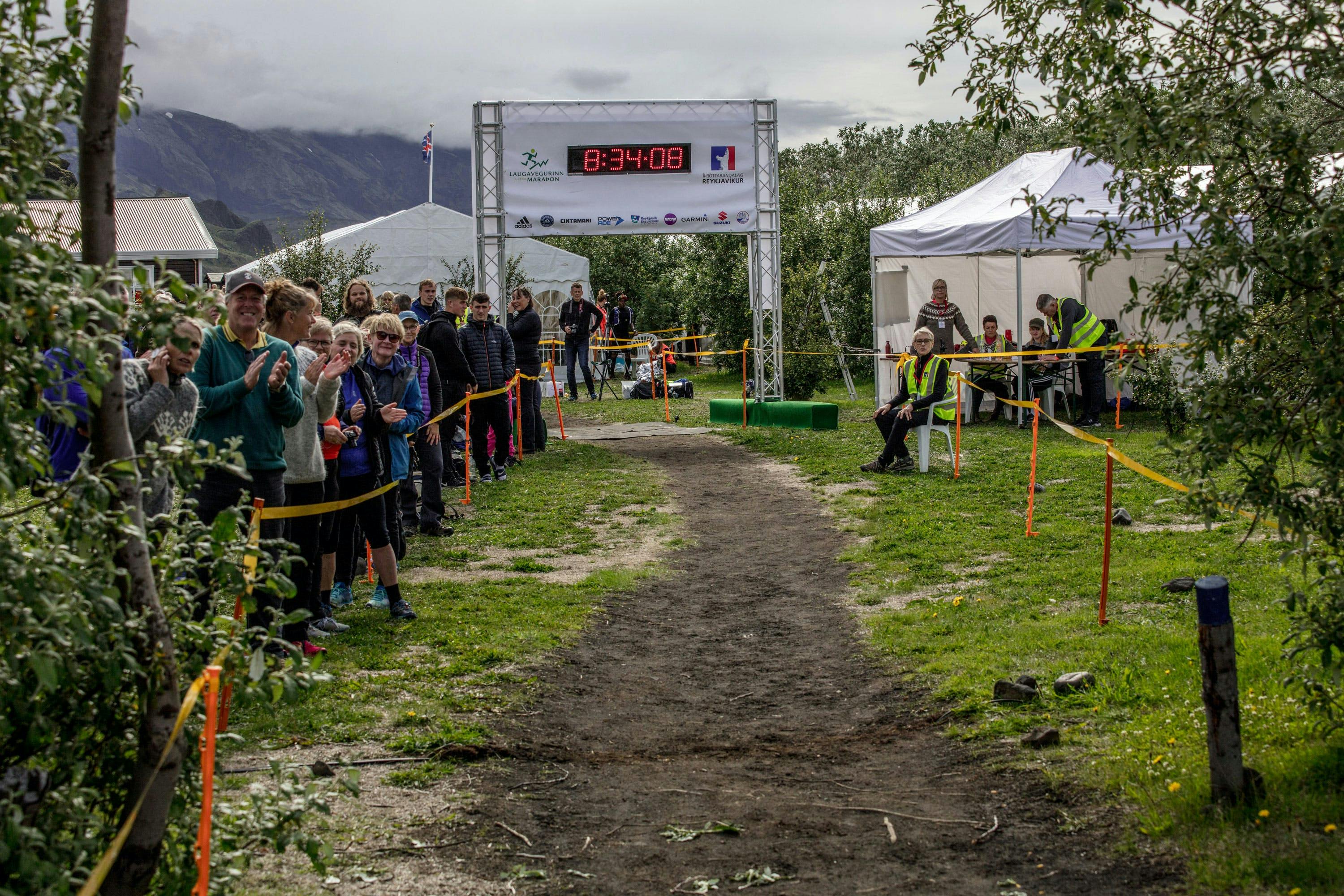 Spectators and race staff giving the Laugavegur Ultra Marathon finishers applause at the finish line in Husadalur. 